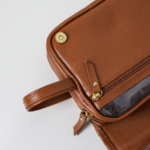 Necessaire de couro legítimo Natache By Tascheers com fechamento em zíper metálico e acabamento artesanal premium.