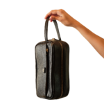 Necessaire de couro legítimo Helena By Tascheers com fechamento em zíper metálico superior, silhueta estruturada e acabamento artesanal premium.