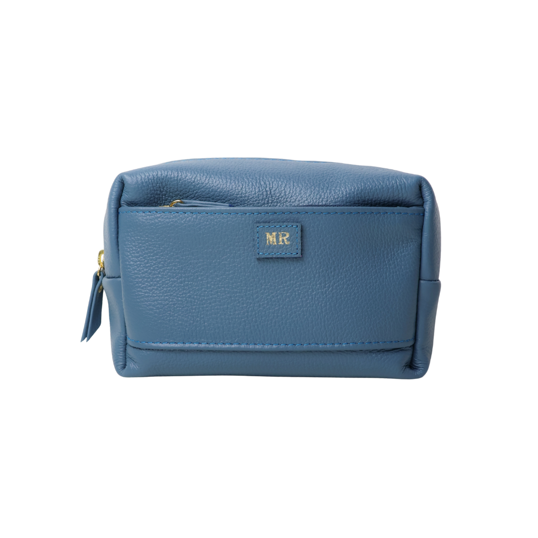 necessaire-jussara-media-azul-jeans-frente Necessaire de couro legítimo Jussara Média By Tascheers com tamanho intermediário, formato estruturado, fechamento em zíper e acabamento artesanal premium.
