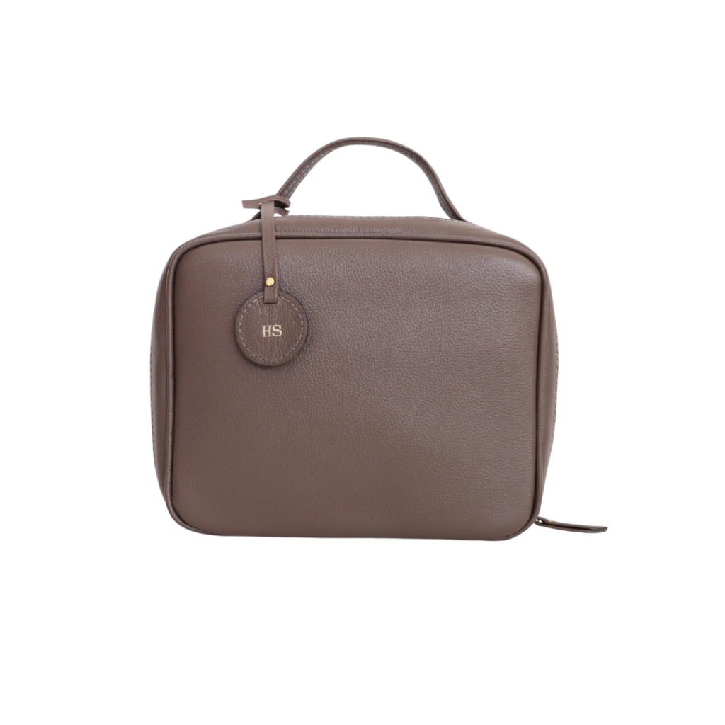 Necessaire de couro legítimo New Bárbara Grande By Tascheers com amplo espaço interno, fechamento em zíper metálico superior e design artesanal estruturado.