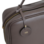 Necessaire de couro legítimo New Bárbara Grande By Tascheers com amplo espaço interno, fechamento em zíper metálico superior e design artesanal estruturado.