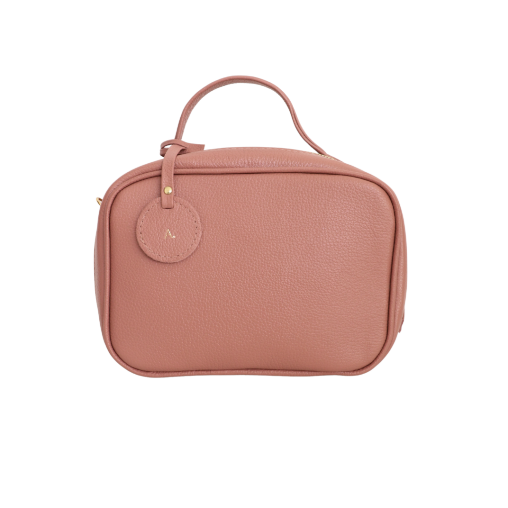 Necessaire de couro legítimo New Bárbara Pequena By Tascheers com formato compacto, fechamento em zíper metálico e acabamento artesanal estruturado.