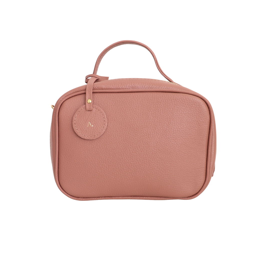 necessaire-new-barbara-pequena-rosa-cha Necessaire de couro legítimo New Bárbara Pequena By Tascheers com formato compacto, fechamento em zíper metálico e acabamento artesanal estruturado.
