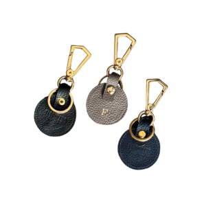 Chaveiro de couro legítimo unissex Isa By Tascheers circular delicado com mosquetão, argola para chaves em ferragem dourada e iniciais gravadas em Hot Stamping.