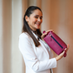 Necessaire de couro legítimo feminina e unissex Olívia By Tascheers com alça de mão, bolso frontal com zíper, forro impermeável e tag redonda personalizada em Hot Stamping.